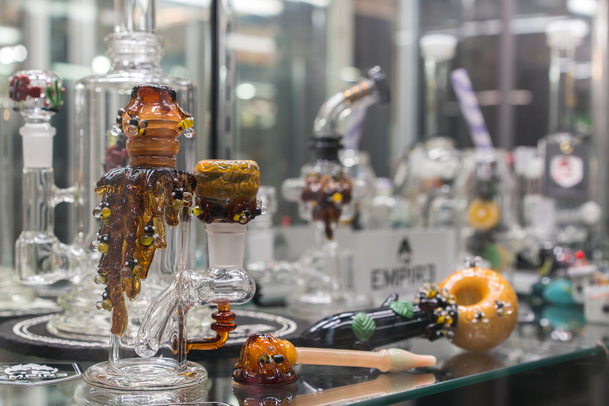 An assortment of different Empire Glassworks handmade pieces on display in a showcase