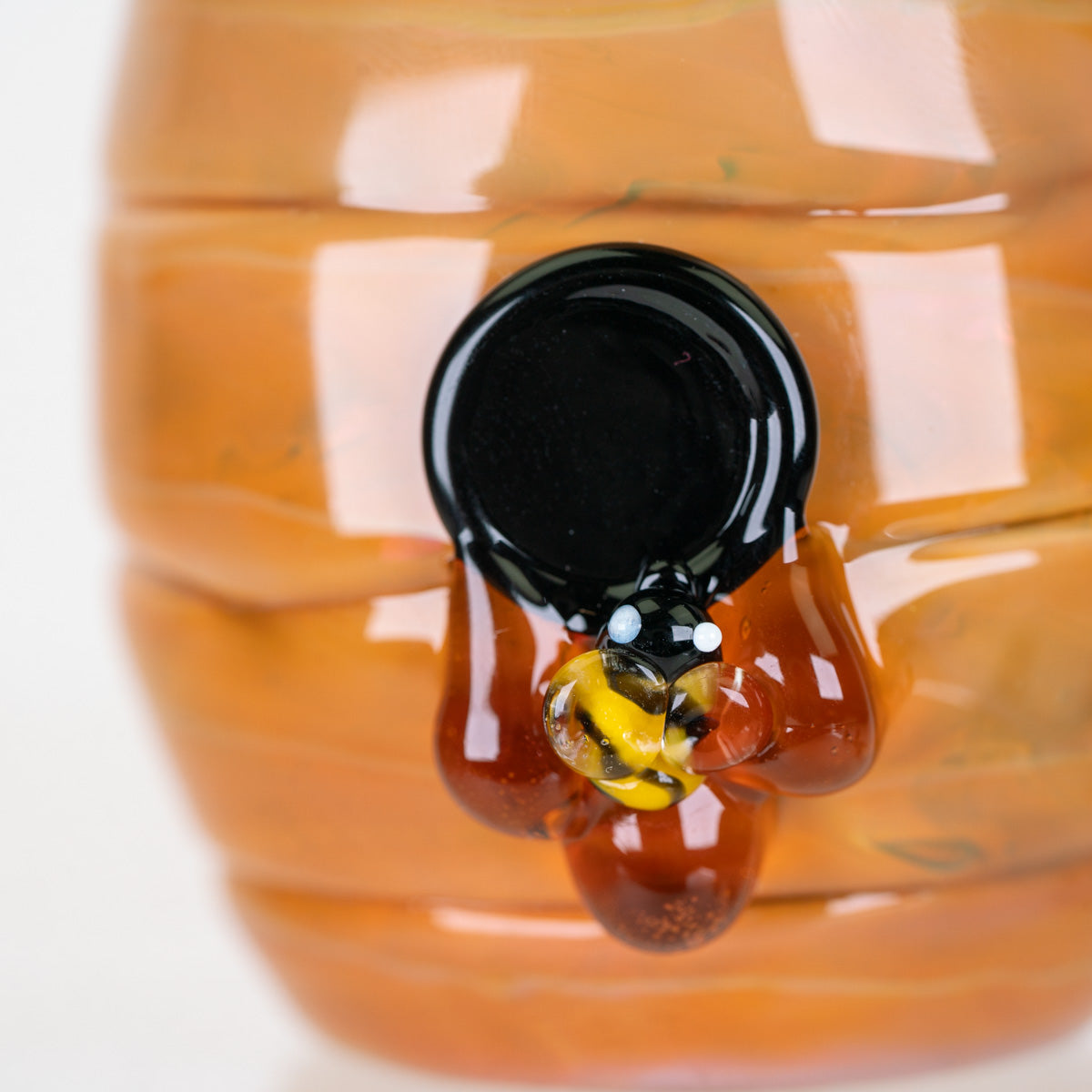 Close-up of Save the Bees Proxy Core attachment showing a miniature sculpted bee on honey-colored glass